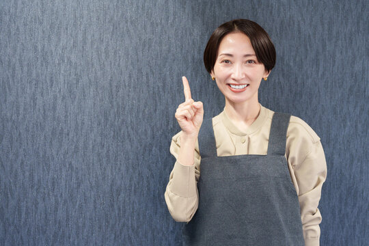 エプロンを着た指差す女性店員