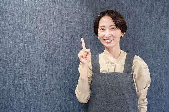 エプロンを着た指差す女性店員