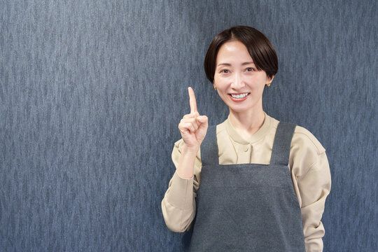 エプロンを着た指差す女性店員