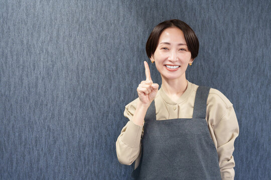 エプロンを着た指差す女性店員