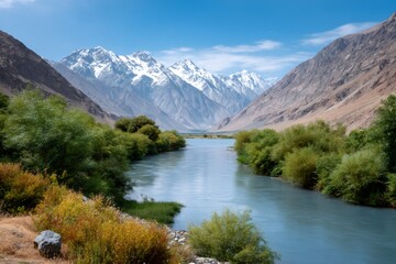 Fototapeta premium Panj river flowing through Wakhan valley with snow-capped mountains