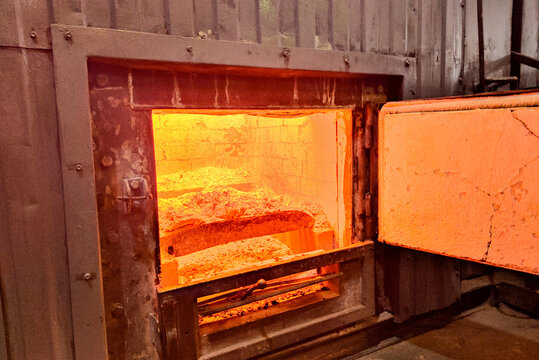 Glowing industrial furnace with open combustion chamber, revealing extreme heat and raw energy used in manufacturing, metal processing, or industrial incineration