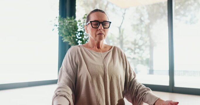 Breathing, exercise and meditation with mature woman in studio for balance, mental health or wellness. Mudra, yoga and zen with person on floor for awareness, inner peace or mindfulness routine