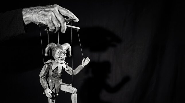 Hand controlling a marionette puppet on strings