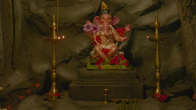 Statue of Ganesha with lamps and flowers, creating a spiritual vibe