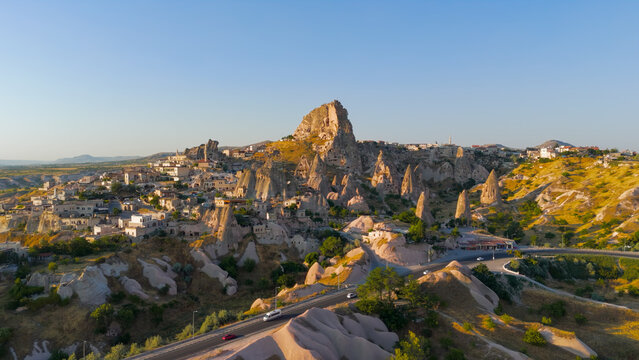 Uchisar, Nevsehir, Turkey. Aerial view of Uchisar Castle, the highest point in Cappadocia, showing rock-cut architecture and surrounding cave houses in morning light.. Aerial View