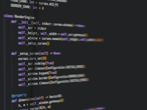 Close up of blurry programming code with pixels on a dark screen
