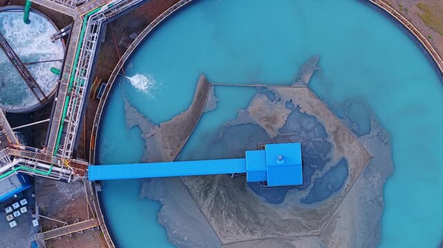 Aerial view of water treatment Industrial facility with rotating clarifier in motion on copper mining factory.