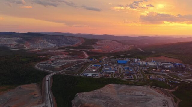 Large open pit mining site with gold ore processing plant factory at sunset Aerial view. Industry landscape of quarry with mineral.