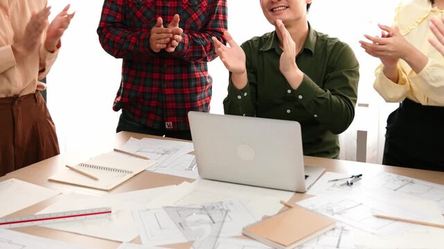 Architect and safety engineer celebrate success design building blueprint project on laptop with architectural document and measurement tool scatter around at modern office. Closeup. Delineation.