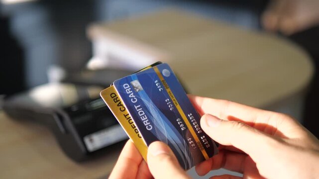 Holding Multiple Credit Cards Near POS Terminal, Consumer Finance and Payment Choice Concept