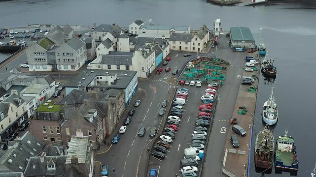 Drone shot of cars parked and boats docked at Stornoway harbour on the Hebrides.