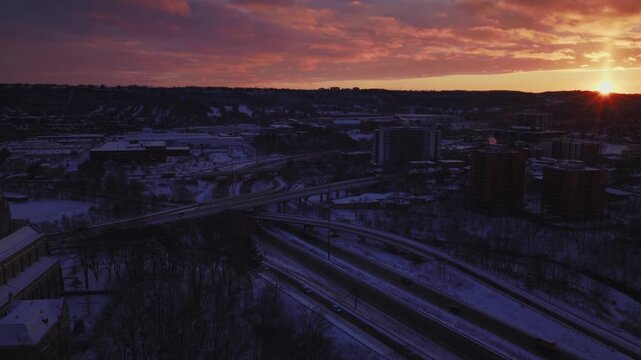 Winter sunset over Hamilton Ontario. The 403 is visible going up the niagara escarpment. The sun is just about to dip below the horizon line.
