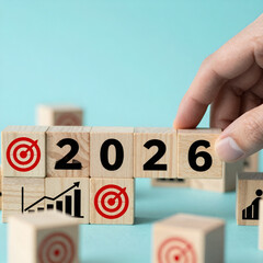 2026 Business Goals and Growth Strategy Concept with Wooden Blocks, Target and Rising Chart Icons, Hand Arranging Future Planning on Blue Background.