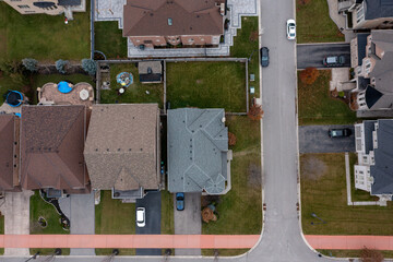 Aerial top down view of a suburban street in brampton, ontario showing detached homes, driveways, green lawns, parked cars and planned neighborhood layout for real estate use