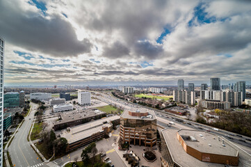 Naklejka premium Toronto cityscape showing highway 427, various office buildings, residential high rises, and urban infrastructure under a cloudy sky covering a large metropolitan area