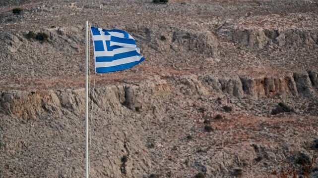 Greek flag with rocky hills on Rhodes, Greece