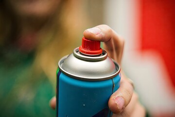 Hand Removing Cap from Spray Paint Can