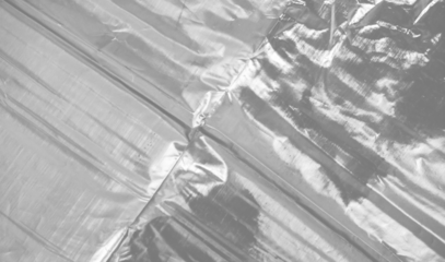 plastic transparent cellophane bag on white background. The texture looks blank and shiny. The plastic surface is wrinkly and tattered making abstract pattern.