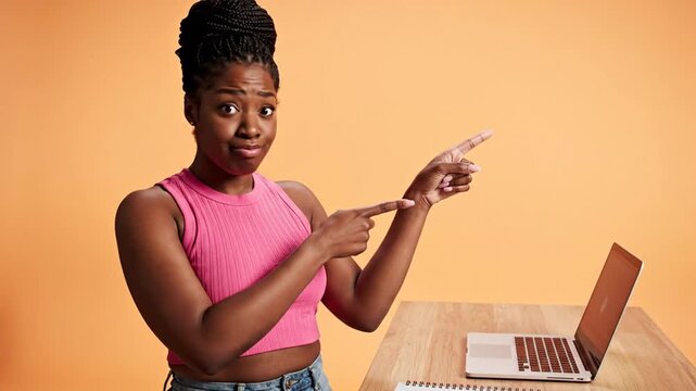 Confused Young Black Woman Gesturing and Presenting Information on the Side near her Desk