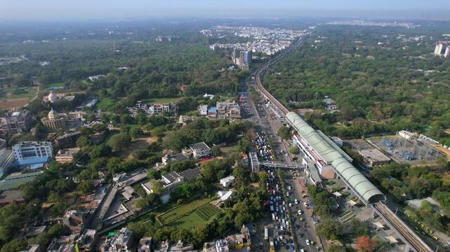Aerial view of Delhi Metro with road traffic at Chhatarpur Metro Station, New Delhi, India