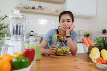 Woman feeling unhappy with diet meal in kitchen