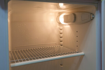 Empty refrigerator with opened door in the kitchen