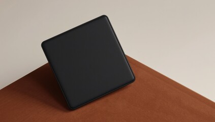 A solitary black wallet rests diagonally on a textured brown surface simple and elegant