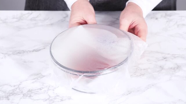 Setting down covered bowl of strawberries