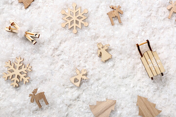 Naklejka premium Composition with different Christmas wooden toys on decorative snow as background, closeup