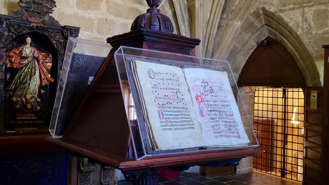 Medieval manuscript. incunabulum book displayed on a wooden lectern. Medieval book with medieval script and calligraphy. Cacers. Spain.