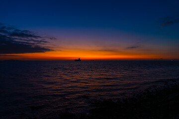 Naklejka premium 夜明けの海と空で朝焼けが映える波間20240105