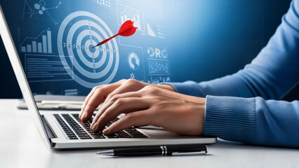 person typing on laptop with business target on screen