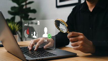 Businessman analyzing data on laptop with magnifying glass