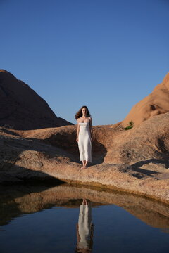 Young women in white dress at the lake of reflection