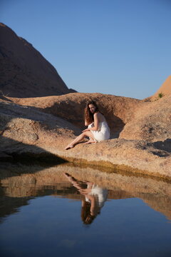 Young women in white dress at the lake of reflection