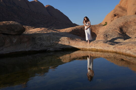 Young women in white dress at the lake of reflection
