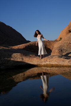 Young women in white dress at the lake of reflection