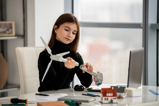 Teenage student assembling wind turbine model, STEM learning