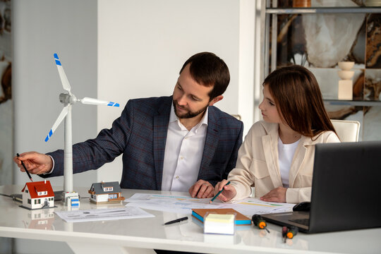 teenage girl is doing research on wind turbines with a mentor.