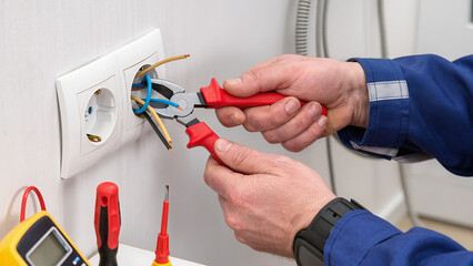 electrician fixing electrical outlet