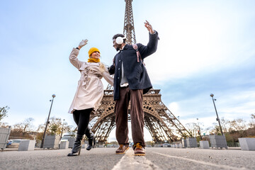 Happy couple dancing on a paris street with tower