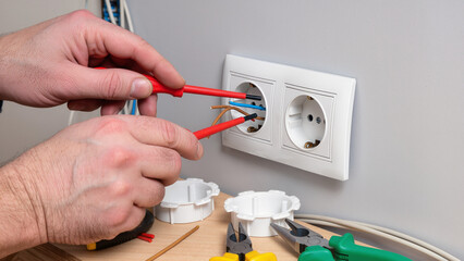electrician fixing electrical outlet