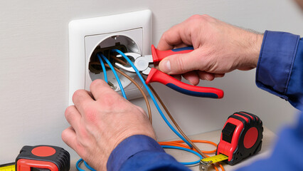 electrician installing electrical outlet