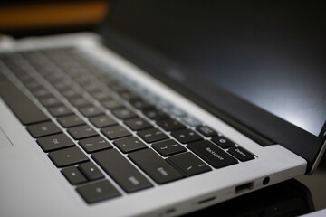 Close up side view of a modern white laptop keyboard and screen