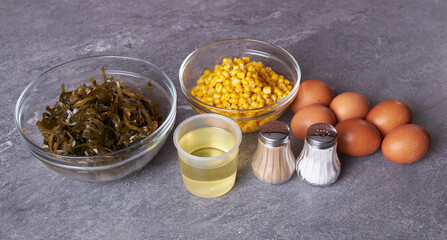 The ingredients for cooking are on the table: seaweed, corn, chicken eggs, vegetable oil, salt and pepper.