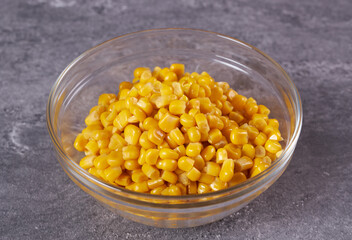 Boiled canned corn in a bowl on the table.