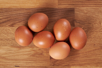 Six chicken eggs on the table.