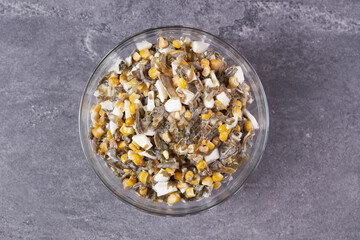 Seaweed, egg and corn salad with mayonnaise in a bowl on the table.