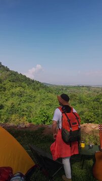 Asian women camping alone with mountain view. Solo outdoor activity and journey lifestyle on holiday.